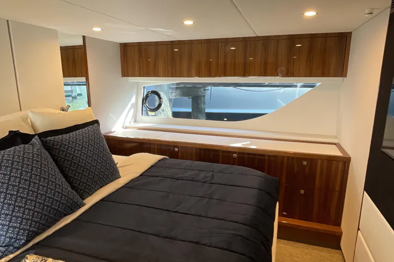 Slide: The Image of Luxurious interior of 2025 Riviera 585 SUV yacht with elegant wood cabinetry and plush bedding. - 53