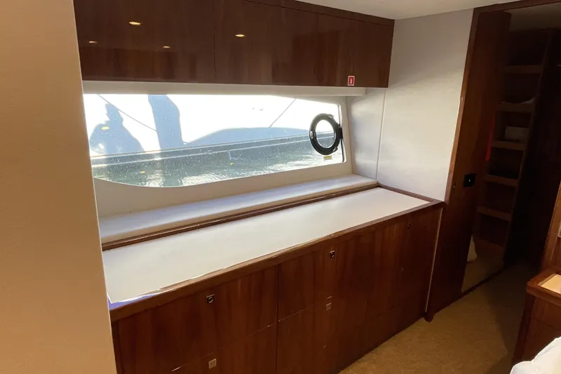 Slide: The Image of Interior of 2025 Riviera 585 SUV yacht with wooden cabinetry and large window. - 54