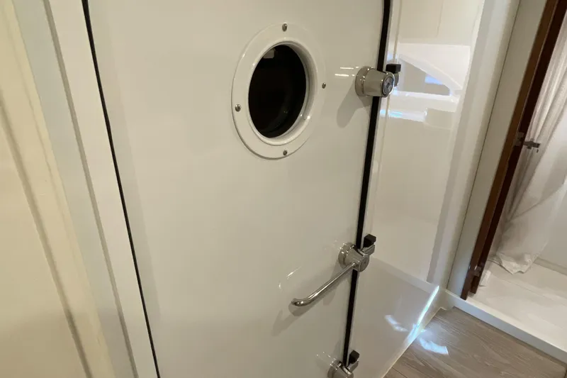 Slide: The Image of Riviera 585 SUV 2025 yacht interior with secure door and porthole. - 62