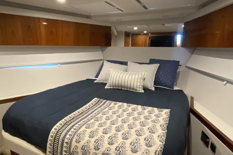 Slide: The Image of Luxurious bedroom interior of 2025 Riviera 585 SUV yacht with elegant bedding and wood accents. - 64