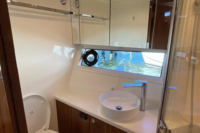 Slide: The Image of Luxurious bathroom in 2025 Riviera 585 SUV yacht with modern fixtures and water view. - 66