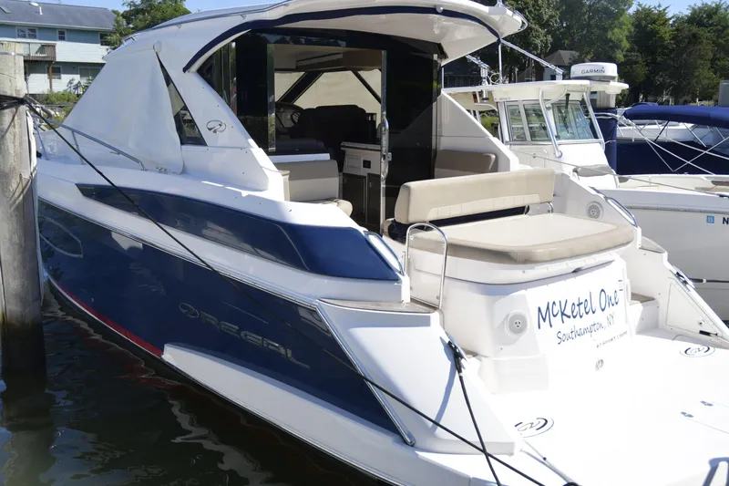 The Image of 2013 Regal 42 Sport Coupe yacht cruising on calm waters under a clear sky. - 0
