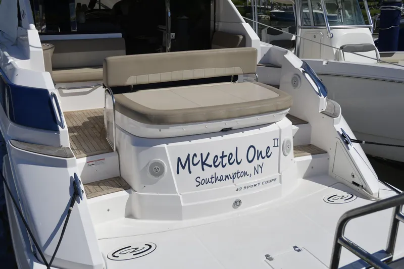 Slide: The Image of 2013 Regal 42 Sport Coupe yacht docked in a serene marina setting. - 1