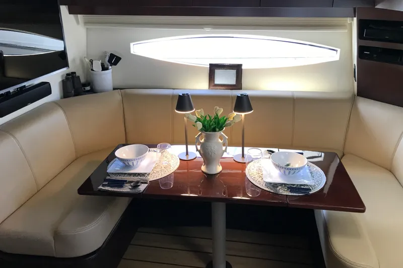 Slide: The Image of Luxurious dining area in a 2013 Regal 42 Sport Coupe yacht with elegant table setting. - 26