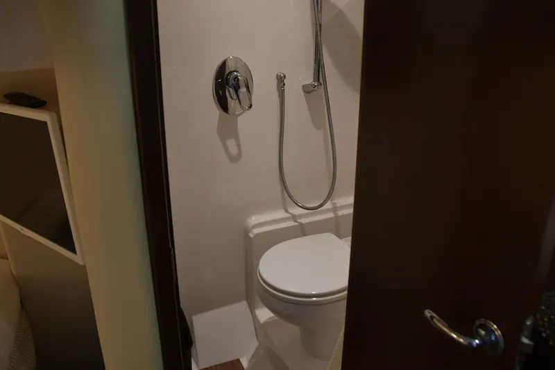 Slide: The Image of Bathroom interior of 2013 Regal 42 Sport Coupe yacht, featuring a compact shower and toilet. - 31