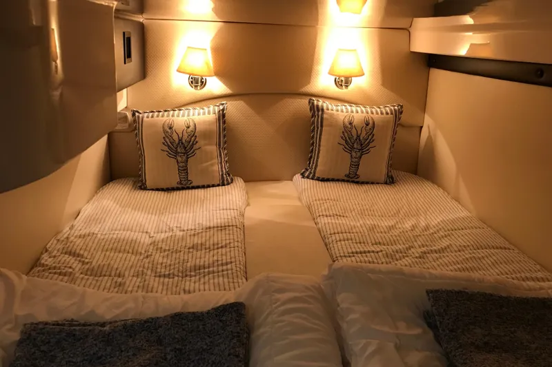 Slide: The Image of Cozy cabin interior of 2013 Regal 42 Sport Coupe with twin beds and nautical decor. - 35