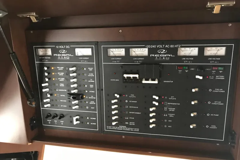 Slide: The Image of Control panel of a 2013 Regal 42 Sport Coupe boat, featuring various switches and gauges. - 38