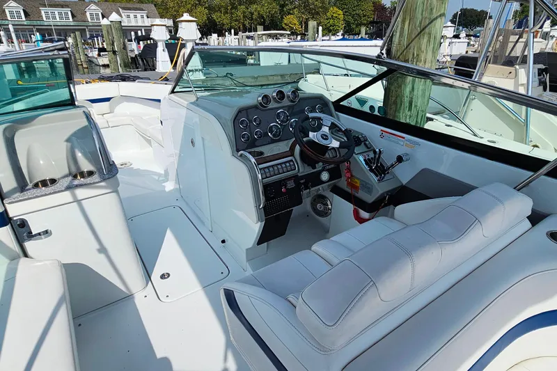 Slide: The Image of 2011 Formula 290 Bowrider interior with helm, seating, and controls at a marina. - 13