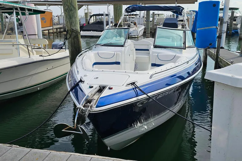 Slide: The Image of 2011 Formula 290 Bowrider boat docked at marina, blue and white exterior. - 2