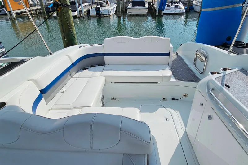 Slide: The Image of 2011 Formula 290 Bowrider with spacious white seating, docked at a marina. - 25