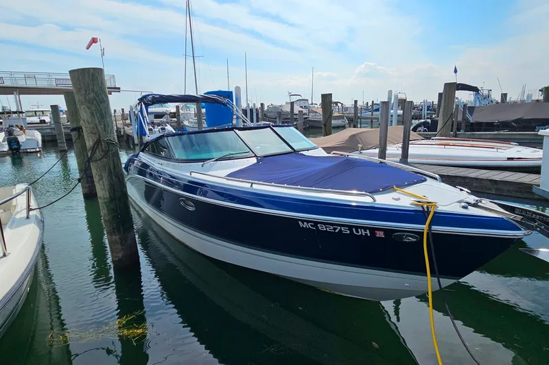 Slide: The Image of 2011 Formula 290 Bowrider docked at marina, blue and white exterior. - 4