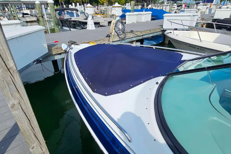Slide: The Image of 2011 Formula 290 Bowrider docked at marina, featuring blue cover and sleek design. - 7