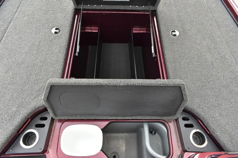 Slide: The Image of 2022 Nitro Z18 boat storage compartment with open lid, showcasing interior layout and cup holders. - 9