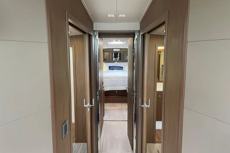 Slide: The Image of Interior of 2017 Beneteau Sense 57 yacht, featuring a cozy bedroom and wooden finishes. - 101