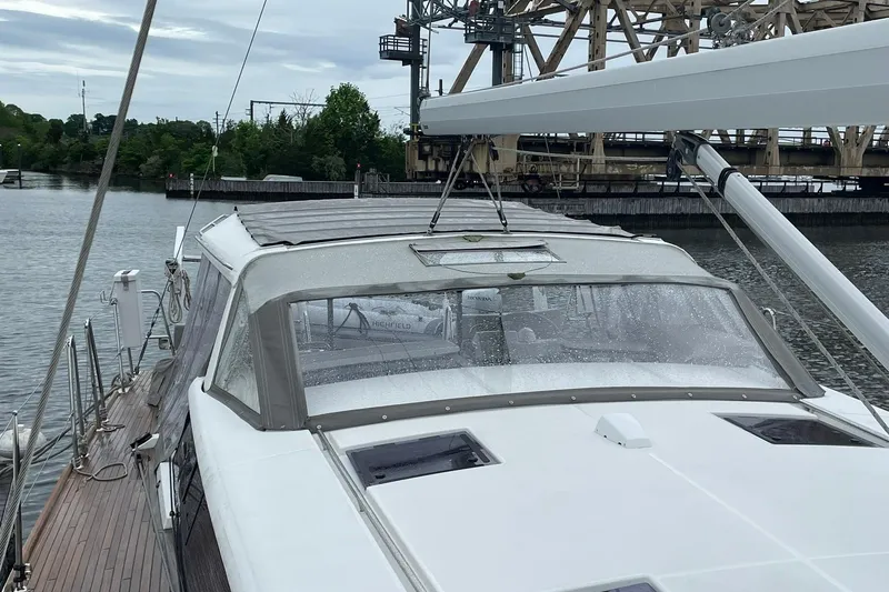 Slide: The Image of 2017 Beneteau Sense 57 yacht docked near an industrial bridge on a cloudy day. - 103
