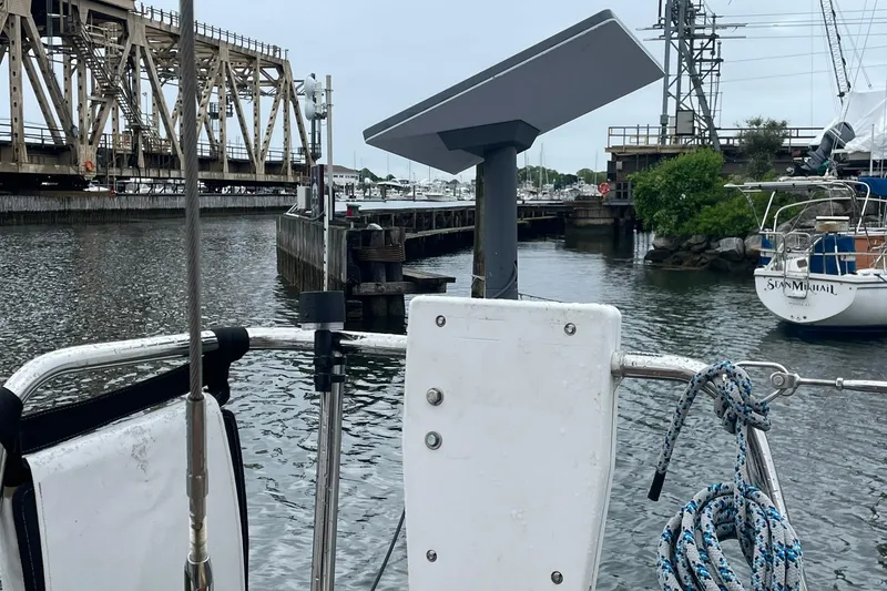 Slide: The Image of Sailboat docked near a bridge, featuring a Beneteau Sense 57, 2017 model. - 107