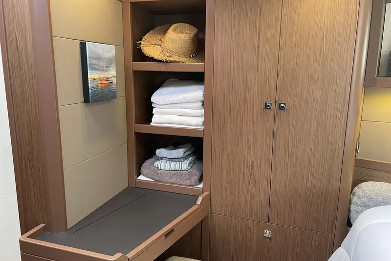 Slide: The Image of Interior of 2017 Beneteau Sense 57 yacht with wooden cabinetry and neatly stacked towels. - 113