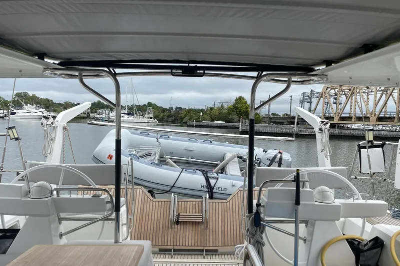 Slide: The Image of 2017 Beneteau Sense 50 yacht with dinghy, docked in a marina, featuring a spacious deck. - 34