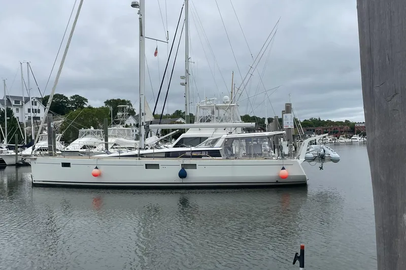 Slide: The Image of 2017 Beneteau Sense 50 yacht docked in a marina, surrounded by other boats. - 36