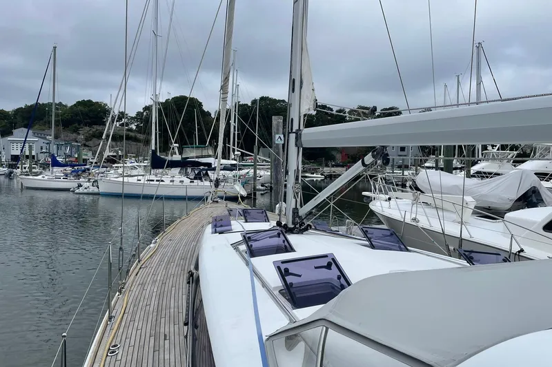 Slide: The Image of 2017 Beneteau Sense 50 yacht docked in a marina, surrounded by other sailboats. - 37