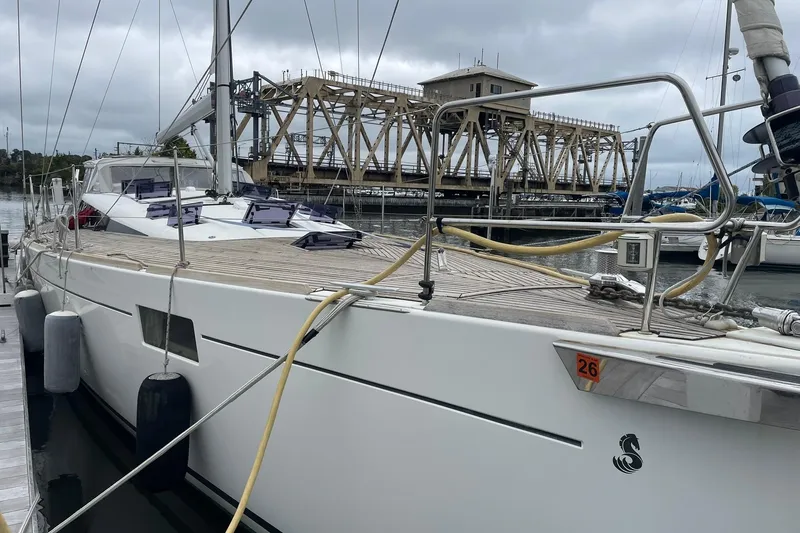 Slide: The Image of 2017 Beneteau Sense 50 yacht docked near a bridge on a cloudy day. - 41