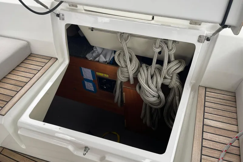 Slide: The Image of Storage compartment on 2017 Beneteau Sense 50 yacht with coiled ropes and wooden flooring. - 52