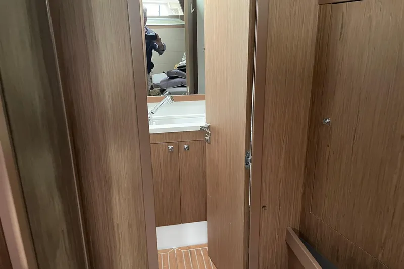 Slide: The Image of Interior of 2017 Beneteau Sense 50 yacht bathroom with wooden cabinetry and sink. - 58