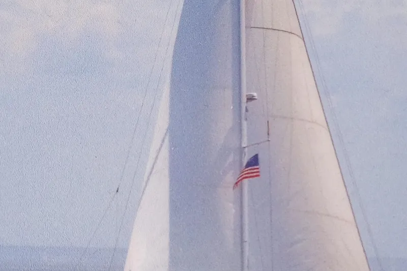 Slide: The Image of 2017 Beneteau Sense 50 sailboat with American flag, sailing under clear skies. - 81