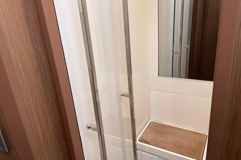 Slide: The Image of Shower area in 2017 Beneteau Sense 57 yacht, featuring sleek glass doors and wooden accents. - 85