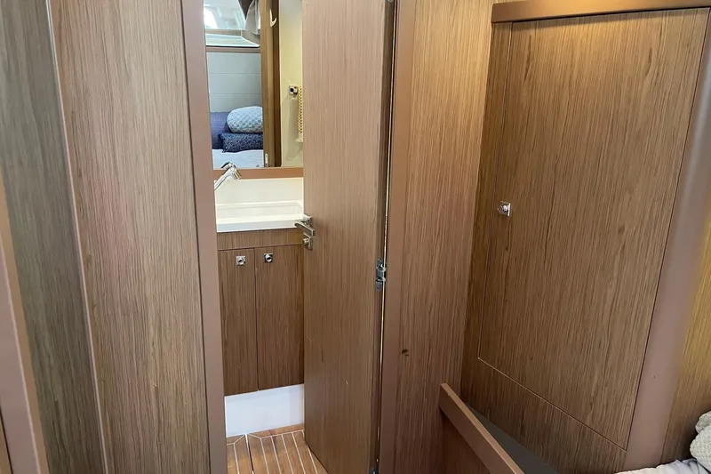 Slide: The Image of Interior of 2017 Beneteau Sense 57 yacht, featuring wooden cabinetry and a compact sink area. - 87