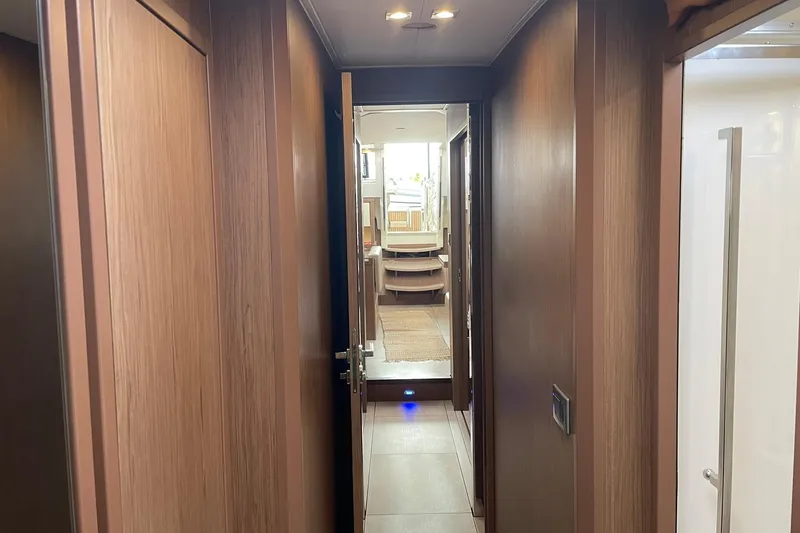 Slide: The Image of Interior hallway of 2017 Beneteau Sense 57 yacht, featuring wooden paneling and modern design. - 95