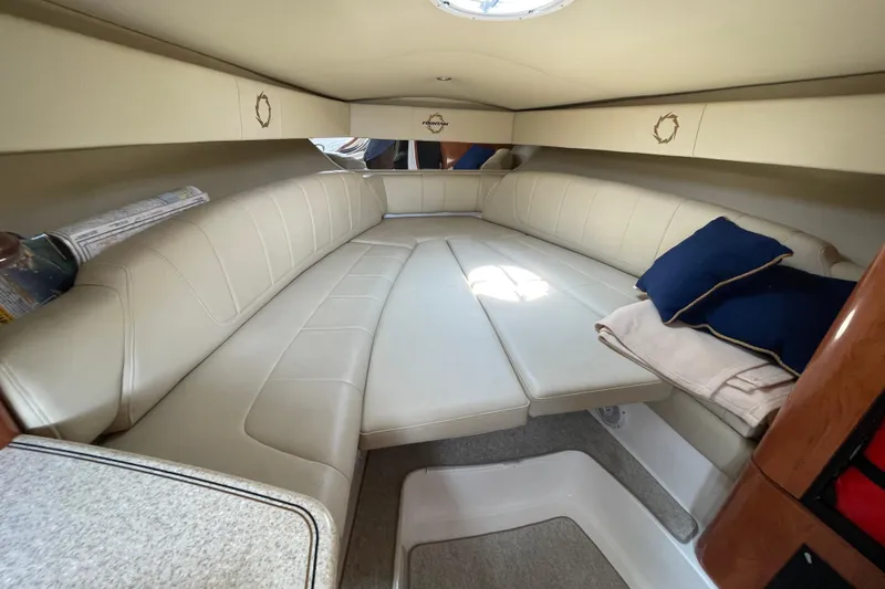 Slide: The Image of 2007 Fountain 38 Sportfish Cruiser OB cabin with beige seating and blue cushions. - 38