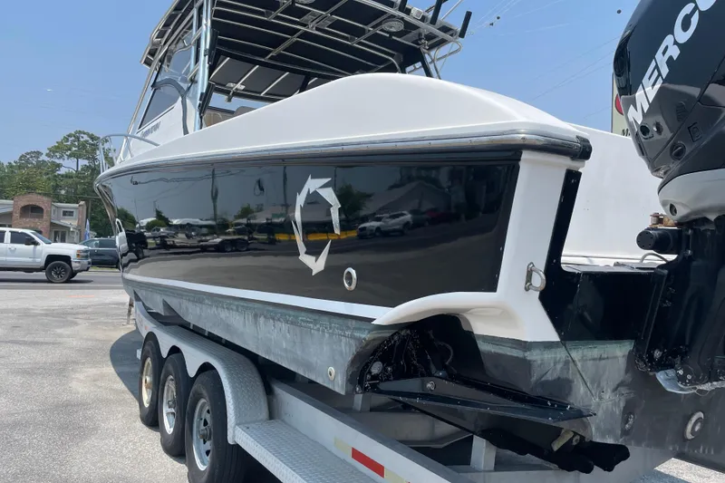 Slide: The Image of 2007 Fountain 38 Sportfish Cruiser OB on trailer, featuring sleek black and white design. - 6