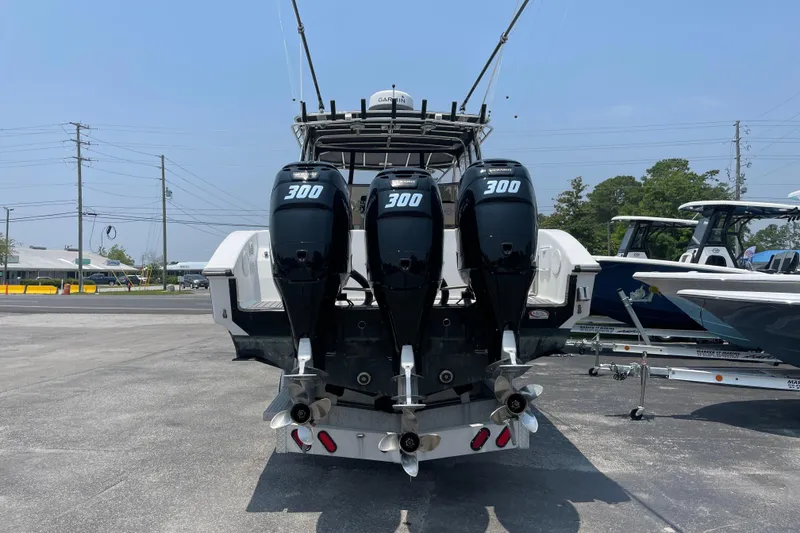 Slide: The Image of 2007 Fountain 38 Sportfish Cruiser OB with triple 300 horsepower outboard engines, parked on pavement. - 7
