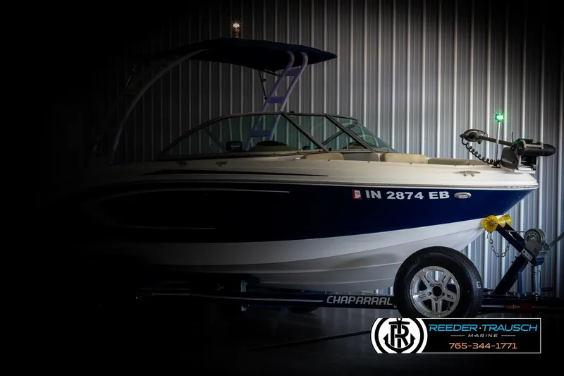 Slide: The Image of 2015 Chaparral 19 H2O Ski & Fish boat on trailer in dimly lit garage. - 4