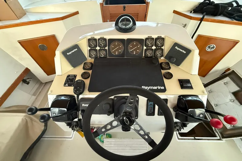Slide: The Image of 1979 Magnum 38 Sport boat dashboard with steering wheel and Raymarine instruments. - 15