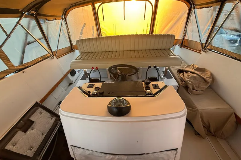 Slide: The Image of 1979 Magnum 38 Sport boat interior with helm, seating, and sunset-lit canopy. - 19