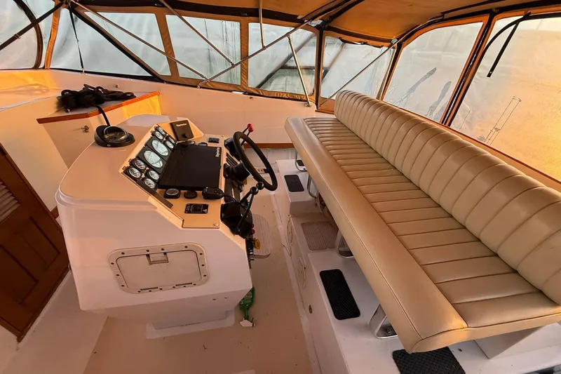 Slide: The Image of 1979 Magnum 38 Sport boat interior with beige seating and control panel. - 22