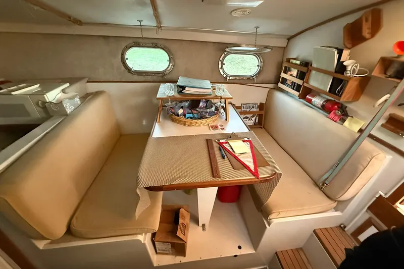 Slide: The Image of 1979 Magnum 38 Sport yacht interior with cozy seating, table, and porthole windows. - 29