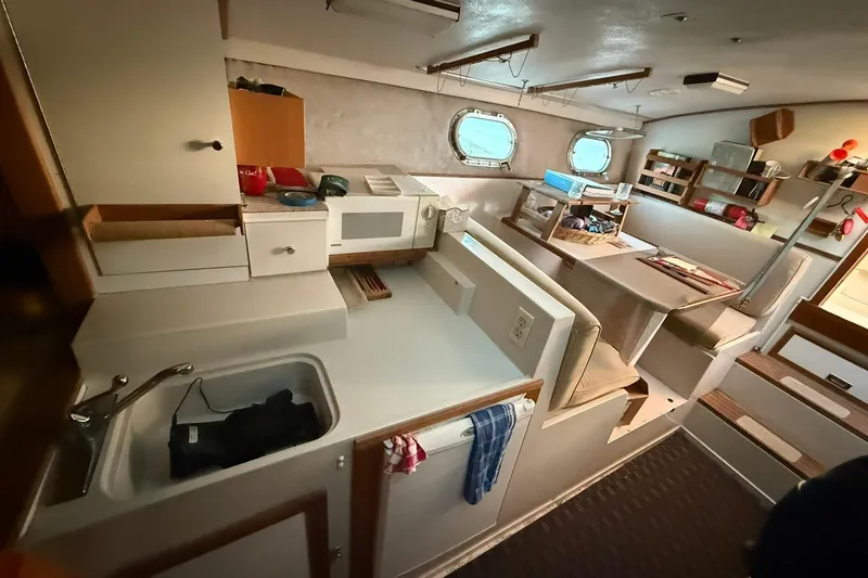 Slide: The Image of Interior of a 1979 Magnum 38 Sport boat featuring a compact kitchen and dining area. - 31