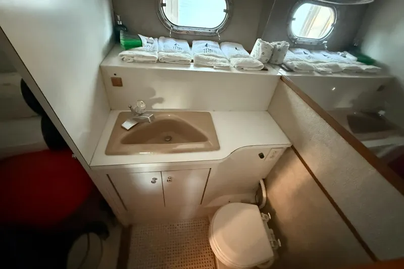 Slide: The Image of 1979 Magnum 38 Sport yacht bathroom with sink, toilet, and porthole windows. - 36