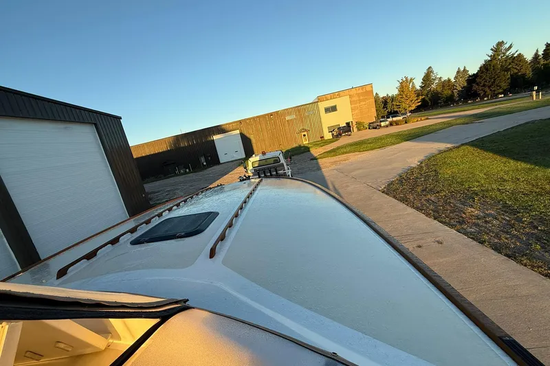 Slide: The Image of 1979 Magnum 38 Sport boat on trailer near industrial buildings at sunset. - 42