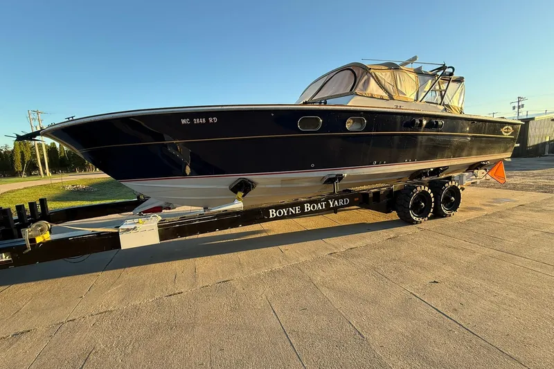 Slide: The Image of 1979 Magnum 38 Sport boat on trailer at Boyne Boat Yard, under clear sky. - 52