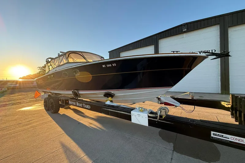 Slide: The Image of 1979 Magnum 38 Sport boat on trailer at sunset near boatyard. - 54