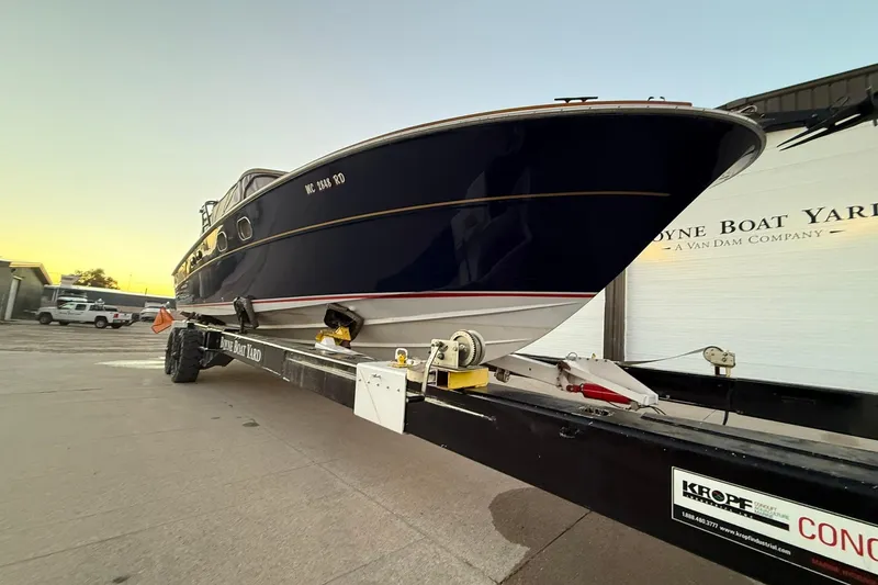 Slide: The Image of 1979 Magnum 38 Sport boat on trailer at sunset, parked near a warehouse. - 7