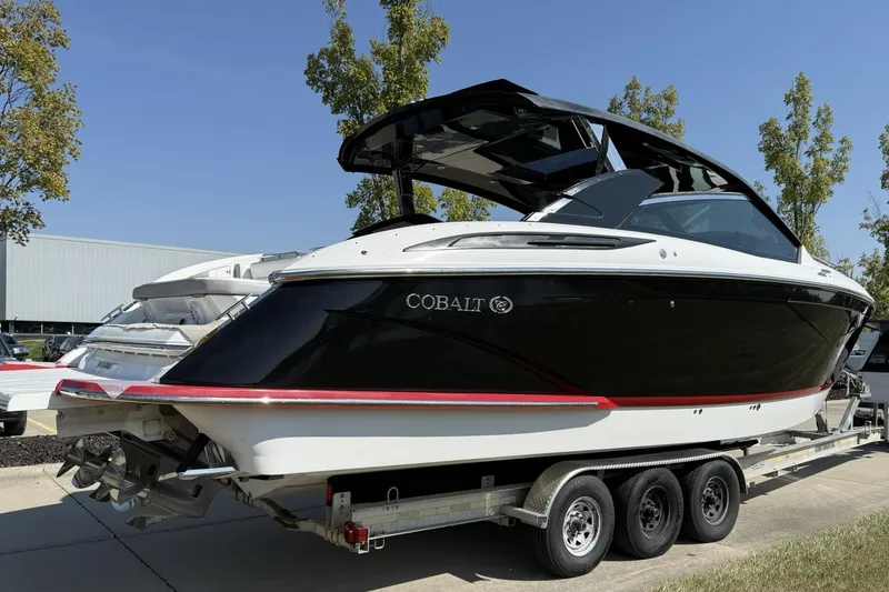 Slide: The Image of 2019 Cobalt A36 boat on trailer, black and white design, parked outdoors. - 2