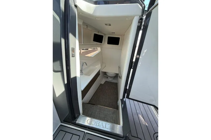 Slide: The Image of Interior of 2019 Cobalt A36 boat showing compact bathroom with sink and toilet. - 21