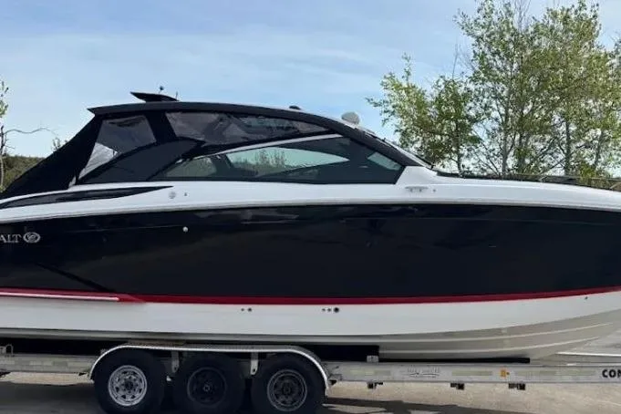 Slide: The Image of 2019 Cobalt A36 boat on trailer, black and white design, parked outdoors. - 3