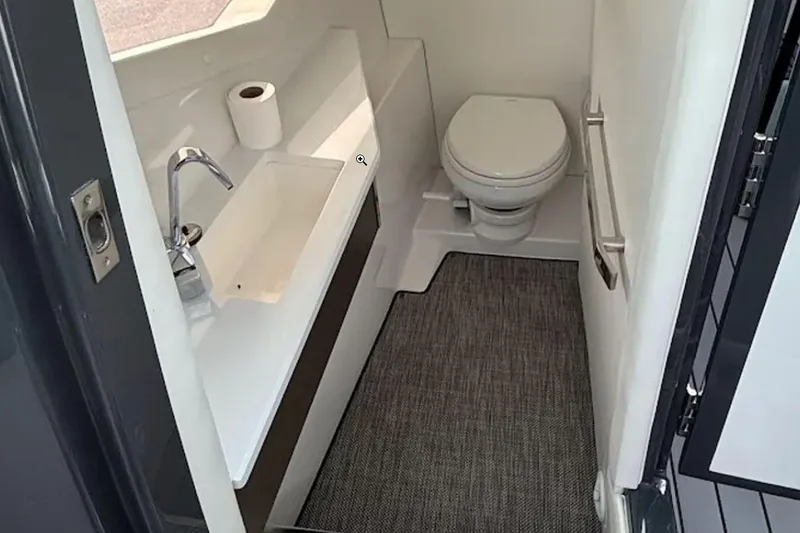 Slide: The Image of 2019 Cobalt A36 boat bathroom with sink, toilet, and carpeted floor. - 8