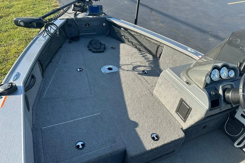 Slide: The Image of 2016 Lund 1775 Pro-V SS boat interior with steering console and carpeted deck. - 11